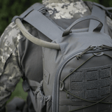M-Tac STURM Elite -reppu käytössä, harmaa 15 l taktinen reppu Cordura-materiaalista, nähtynä takaa MOLLE Laser Cut -paneelilla.