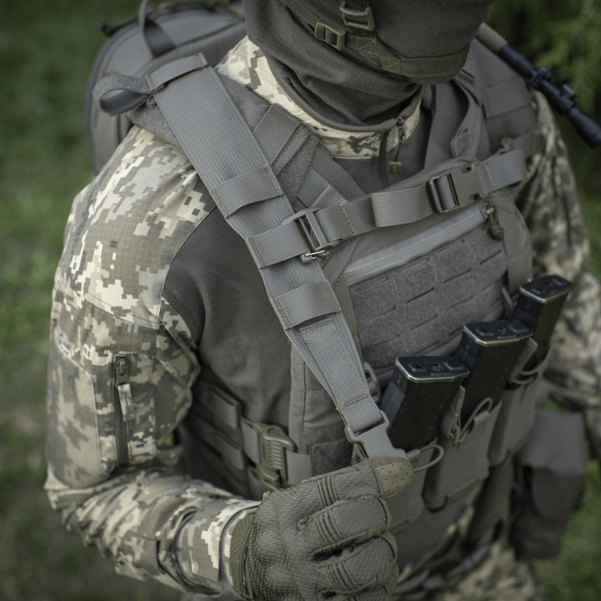 Taktinen sotilas M-Tac STURM Elite -repun kanssa metsäympäristössä, maastokuvioitua varustusta ja MOLLE Laser Cut -etupaneeli.