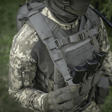 Taktinen sotilas M-Tac STURM Elite -repun kanssa metsäympäristössä, maastokuvioitua varustusta ja MOLLE Laser Cut -etupaneeli.