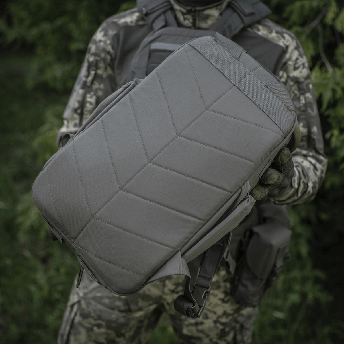 M-Tac STURM Elite -reppu taktiseen käyttöön 15 l kapasiteetilla ja kulutusta kestävä Cordura-materiaali, pidetään maastopuvun käyttäjän toimesta.