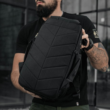 M-Tac STURM Elite -reppu mallin pitämänä ulkona, esittelee taktista muotoilua ja kestävyyttä, sopii lyhytaikaisiin kenttäoloihin.