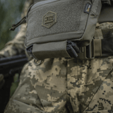 M-Tac Large Elite Gen.II olkalaukku, taktinen olkalaukku Cordura 500D:stä YKK-vetoketjuilla, nähtynä maastokuvioidun univormun päällä.