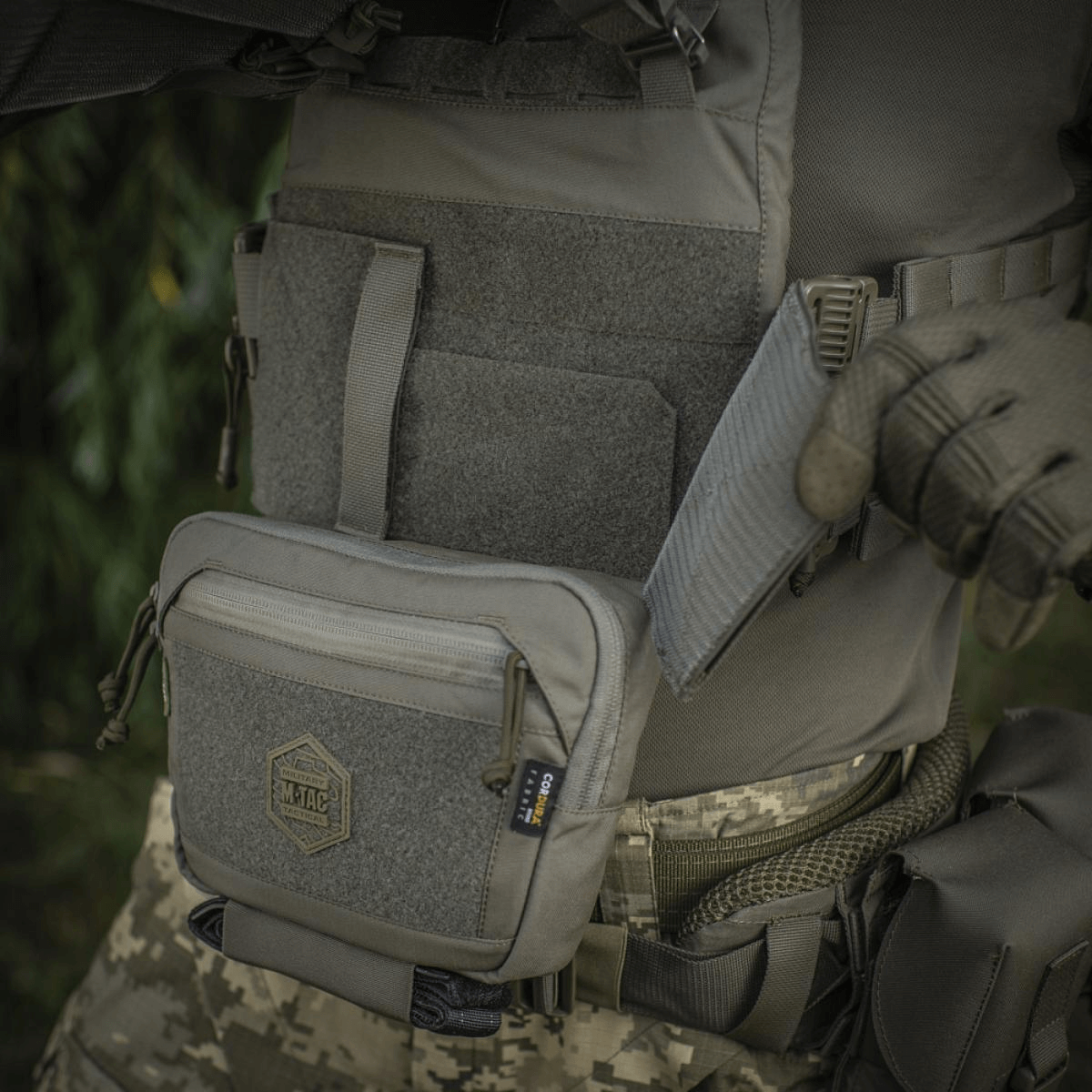 M-Tac Large Elite Gen.II olkalaukku käytössä, valmistettu kestävästä Cordura 500D:stä, luotettavat YKK-vetoketjut ja Velcro-paneeli.