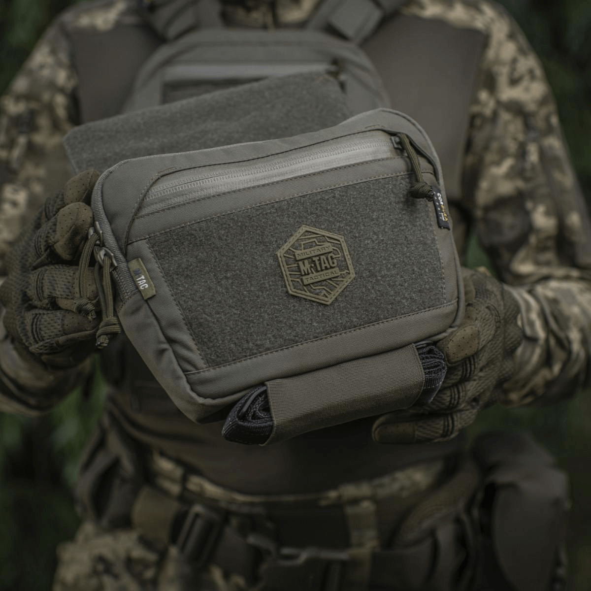 M-Tac Large Elite Gen.II olkalaukku Cordura 500D:stä YKK-vetoketjuilla, nähty taktisen maastovarustuksen yhteydessä.