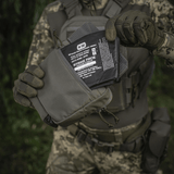 M-Tac Large Elite Gen.II olkalaukku taktisten varusteiden kanssa, valmistettu Cordura 500D:stä, käytössä päivittäiseen säilytykseen.