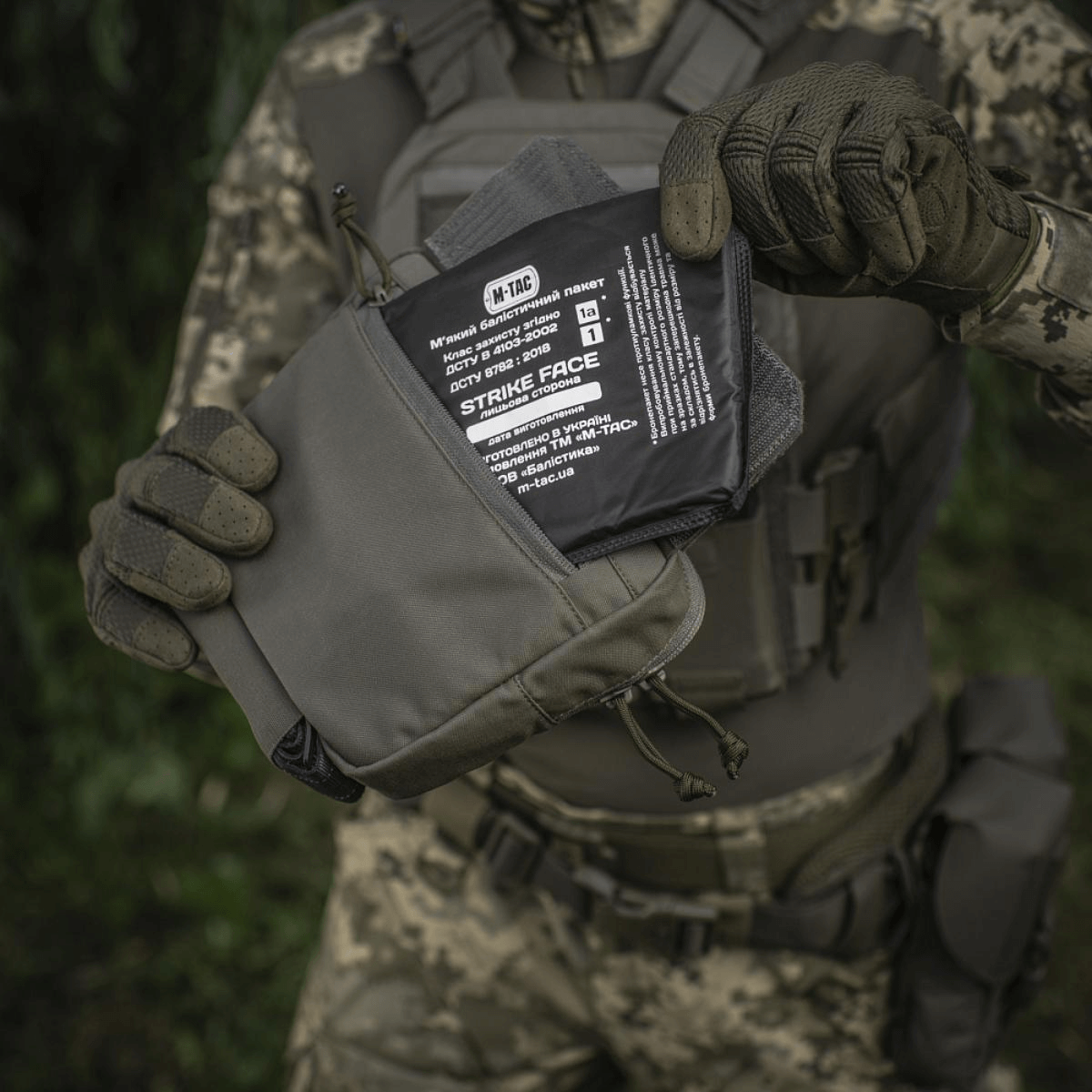 M-Tac Large Elite Gen.II olkalaukku taktisten varusteiden kanssa, valmistettu Cordura 500D:stä, käytössä päivittäiseen säilytykseen.
