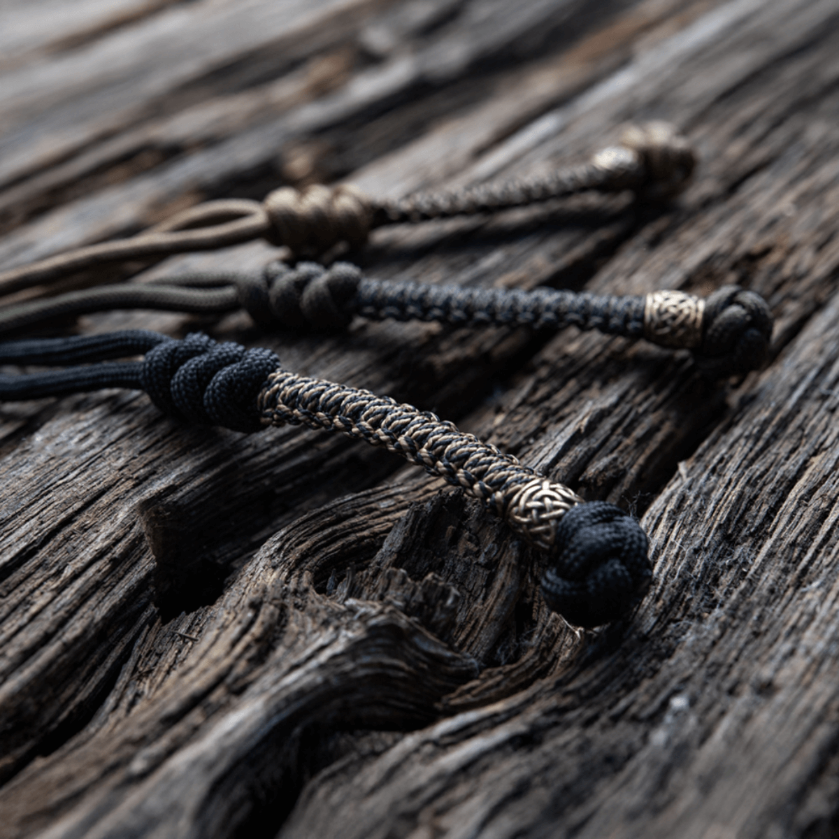 M-Tac Knife Lanyard Scandinavian punottu paracord-lisä taskuveitsille puupinnalla, tyylikäs ja käytännöllinen lisä.