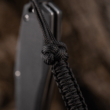 M-Tac Knife Lanyard Celtic, musta punottu paracord, korostaa veitsen muotoilua ja käytännöllisyyttä.