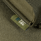 Lähikuva M-Tac pystysuorasta kaasupullonpidikkeestä, valmistettu tukevasta materiaalista, selkeä M-Tac-logo, nopea pääsy kaasupulloille.