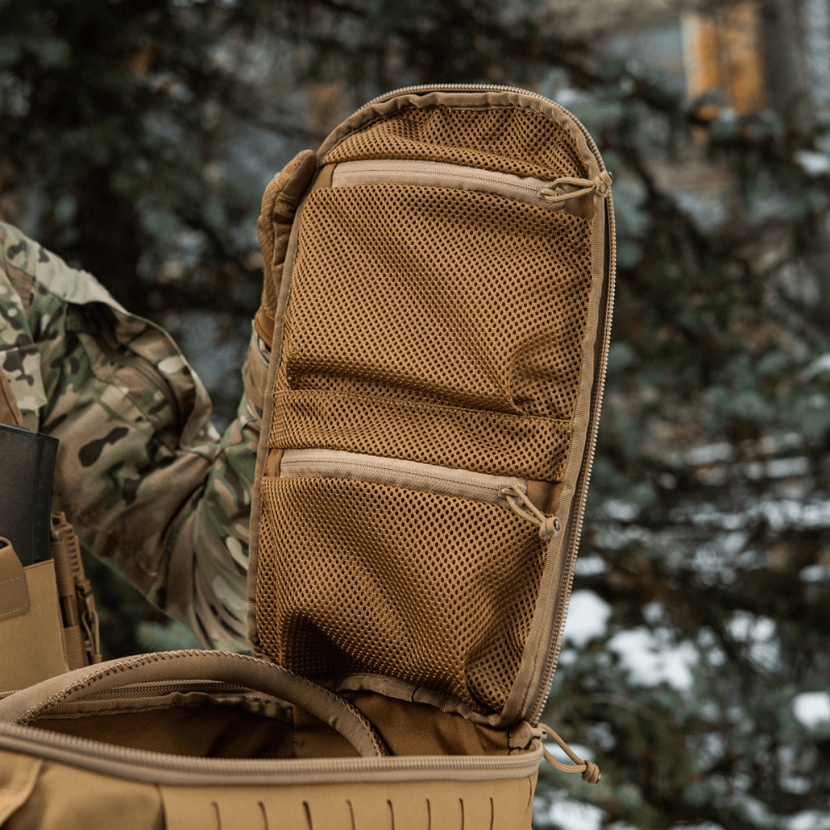 M-Tac reppu Sturm Elite Gen.II avattuna laukkumaisen osion kanssa ja kaksi verkkotaskua EDC-varusteille metsässä.