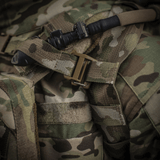 M-Tac reppu Sturm Elite Gen.II juomajärjestelmällä ja maastokuvioinnilla, lähikuva soljesta ja juomaletkusta.