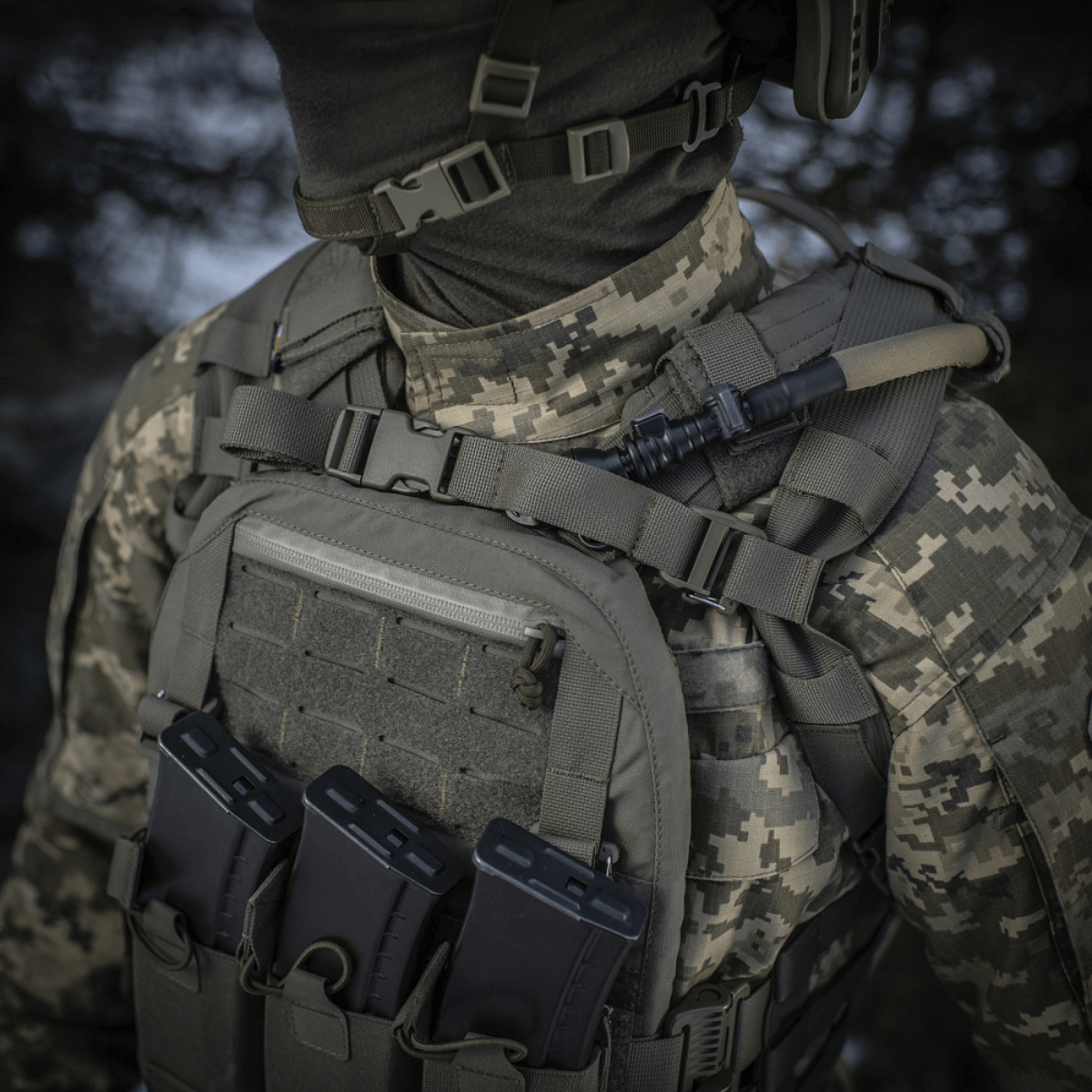 M-Tac Sturm Elite Gen.II sotilaan kantamana, maastokuvioasu ja taktinen varustus, MOLLE edessä näkyvissä.