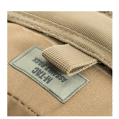 M-Tac Assault Pack, MOLLE-järjestelmä ja pehmustetut olkahihnat, lähikuva etiketistä beigen repun.