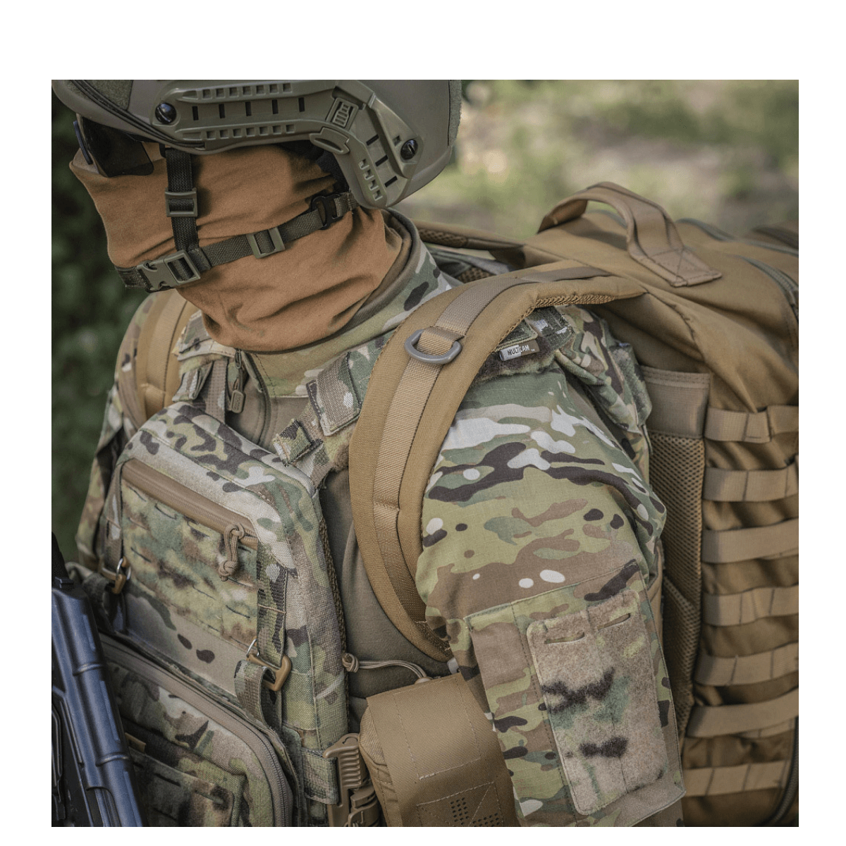 M-Tac Large Assault Pack -reppu MOLLE-järjestelmällä ja pehmustetuilla olkahihnoilla, nähtynä henkilöllä maastovarusteissa.