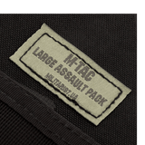 Lähikuva M-Tac Large Assault Pack -repun etiketistä, tuotemerkin logo ja nimi näkyvissä