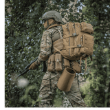 M-Tac Large Assault Pack -reppu käytössä henkilöllä maastopuvussa metsäympäristössä, MOLLE-järjestelmä ja säädettävät olkahihnat.