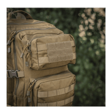 M-Tac Large Assault Pack -reppu taktiseen muotoiluun, MOLLE-järjestelmä ja lisätaskuja, kuvattu tiheässä metsässä.