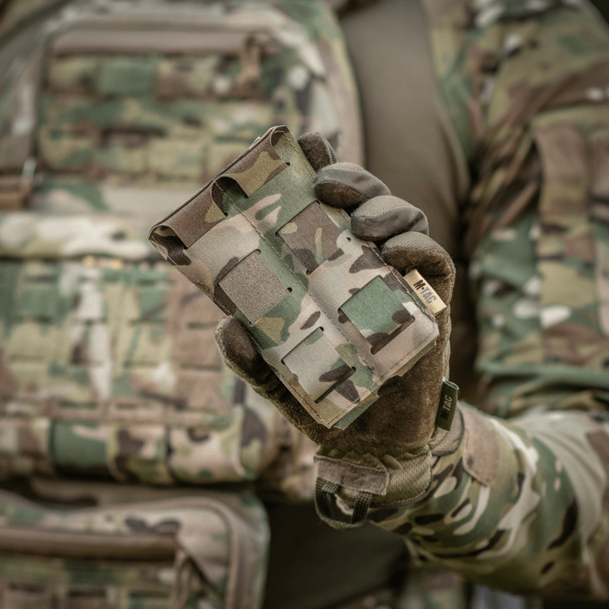 M-Tac Double Magazine Pouch APS Laser Cut käytössä, pidetään henkilön toimesta camo-vaatetuksessa. Kevyt, kompakti kahdelle APS-lippaalle.