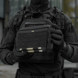 M-Tac Admin Pouch Large Elite mustana, pidetään henkilön toimesta taktisten vaatteiden yllä, valmistettu Cordura 500D:stä.