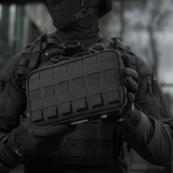 Henkilö pitelee M-Tac Admin Pouch Large Eliteä mustana, toimiva laukku taktisiin varusteisiin, Cordura 500D, tarrat ja laser-leikkaukset.