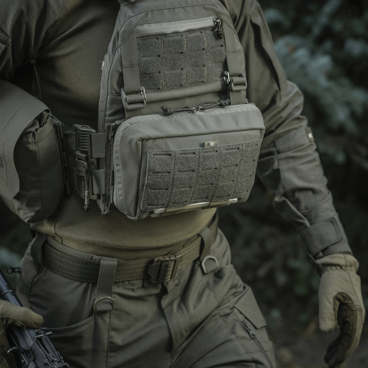 M-Tac Admin Pouch Large Elite taktista varustusta kantavan henkilön mukana luonnossa, näyttää toimivan säilytyksen ja kestävyyden.