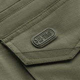 Lähikuva M-Tac Shorts Aggressor Gen.II Flexin taskumuotoilusta vihreässä ripstop-kankaassa, taktinen ommel ja M-Tac-merkintä.