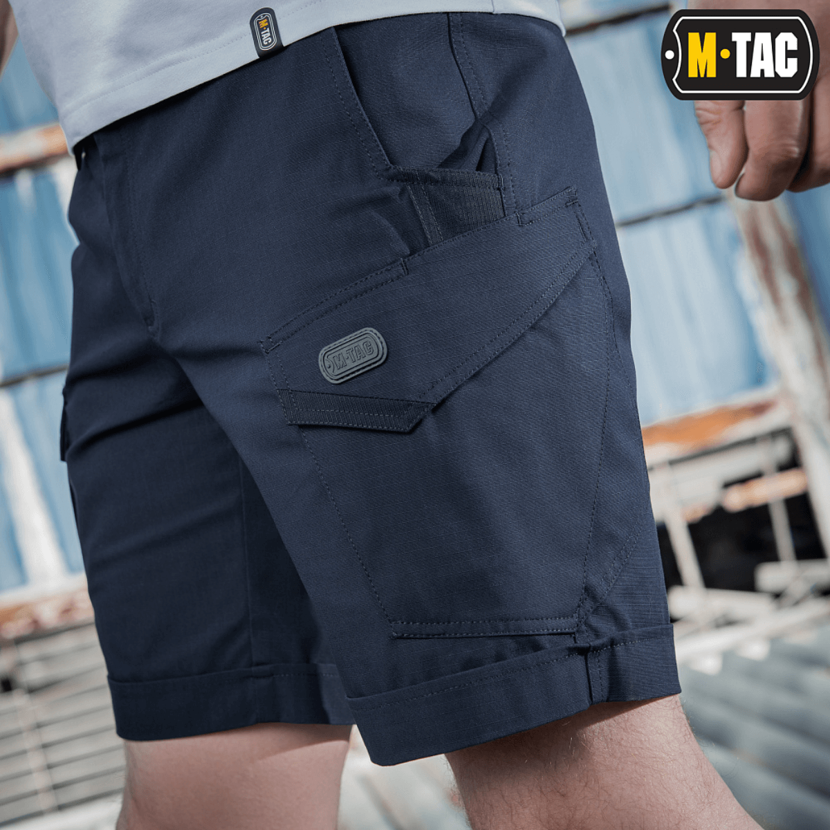 M-Tac Shorts Aggressor Short merensinisenä taktisin taskuin, suunniteltu mukavuuteen ja liikkumisvapautta varten, täydellinen kaupunki- tai luontokäyttöön.