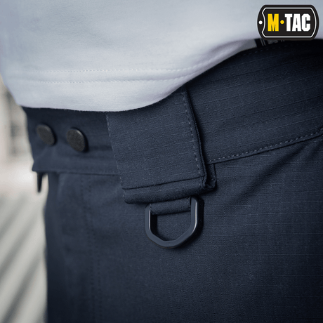Lähikuva M-Tac Shorts Aggressor Shortista D-renkaalla ja joustavilla vyölenkeillä, suunniteltu mukavuuteen ja joustavuuteen polycotton Flex rip-stop -materiaalissa.