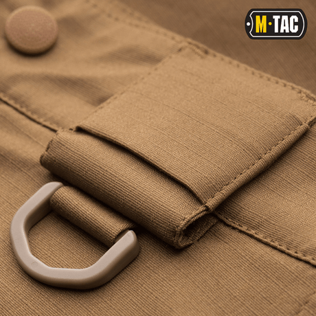 Lähikuva M-Tac Shorts Aggressor Shortin D-renkaasta ja rip-stop-materiaalista, ihanteellinen taktiseen käyttöön ja mukavuuteen lämpimissä ilmastoissa.