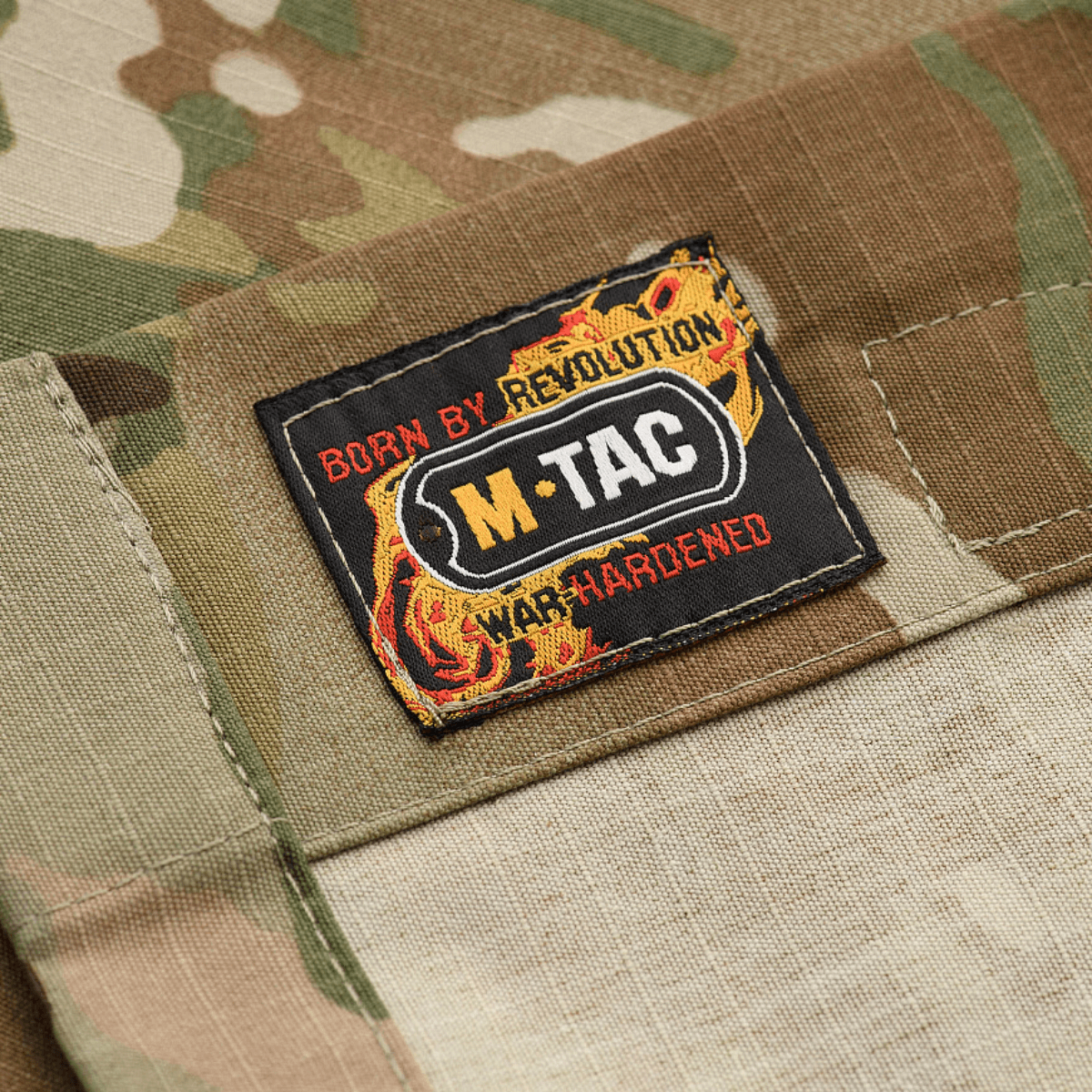 M-Tac Military Elite NYCO -takki alkuperäisellä Crye Precision MultiCam-kankaalla, lähikuva M-Tac-logosta camotakissa. Sopii kenttäasu-yhdistelmään