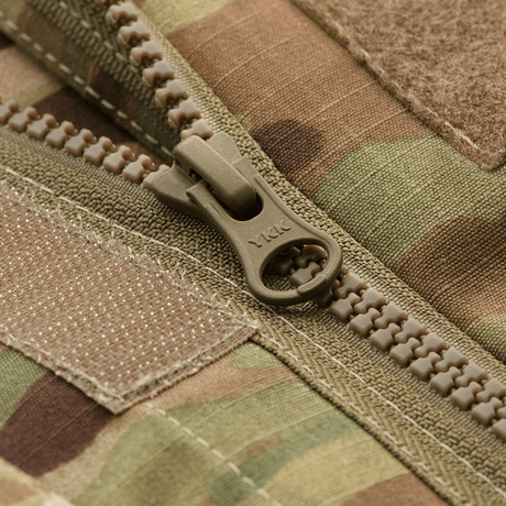 Lähikuva YKK-vetoketjusta M-Tac Military Elite NYCO -takissa MultiCam-kuosissa, näyttää yksityiskohtaisen rakenteen ja muotoilun