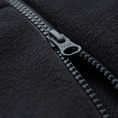 Lähikuva vetoketjusta M-Tac Lite Microfleece Hættetrøje -tuotteessa, mustassa mikrofleece-materiaalissa, näyttää rakenteen ja vetoketjun muotoilun.