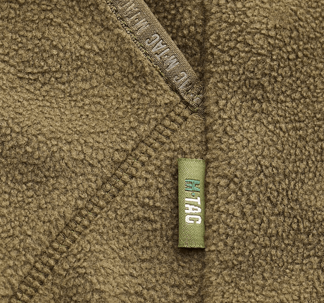 Yksityiskohta M-Tac Lite Microfleece Hættetrøje -tuotteesta mesh-strukturenilla ja joustavalla reunanauhalla, ihanteellinen mukavuuteen ja liikkumisvapauteen.