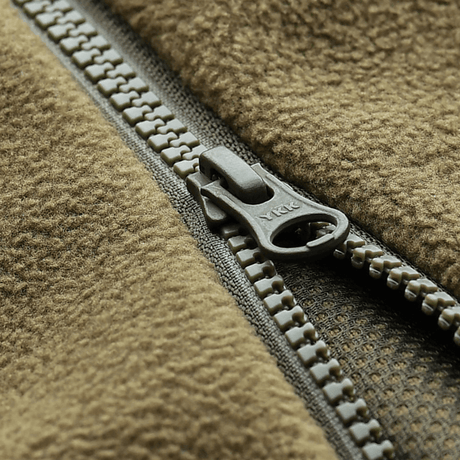 Lähikuva vetoketjusta M-Tac Lite Microfleece Hættetrøje -hupparissa, korostaa joustavaa mikrofleeceä ja mesh-strukturia.