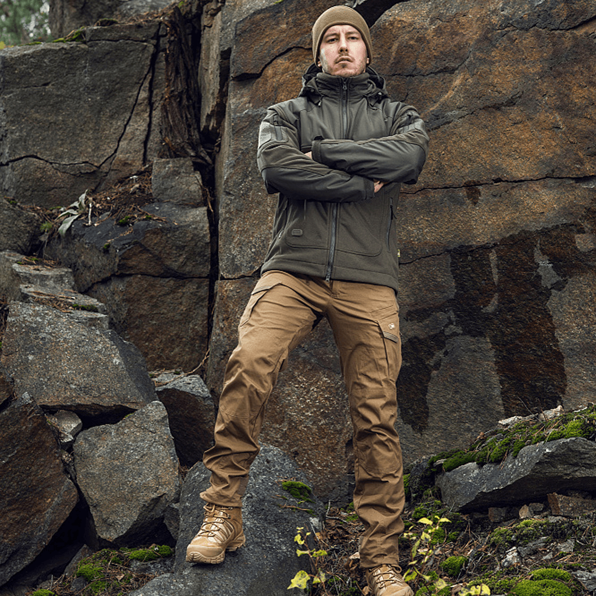 Mies pukeutuneena M-Tac Norman Windblock -fleecetakkiin kallion edessä, kestävä ja tyylikäs ulkovaatetus luonnossa.