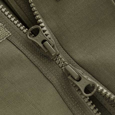 Yksityiskohta M-Tac Patrol Flex -takista kestävästä YKK-vetoketjusta ja Velcro-peitteestä, sopii taktiseen ja käytännölliseen vaatetukseen.