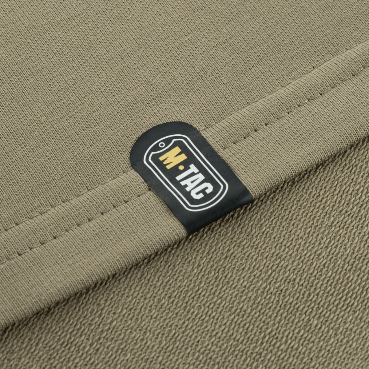 Lähikuva M-Tac Pullover 4 Seasons -venyvästä kangasetiketistä, sopii arki- ja taktiseen käyttöön ympäri vuoden