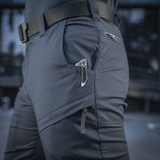 Mies pukeutuneena M-Tac Tactical Bukser Patrol Gen II Flex, taktiset taskut ja vyö.