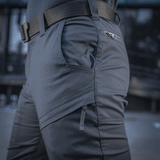 M-Tac Tactical Bukser Patrol Gen II Flex toiminnassa, näyttää käytännölliset vetoketjutaskut ja säädettävän vyön optimaalista istuvuutta ja toimivuutta varten.