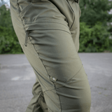 M-Tac Tactical Bukser Patrol Gen II Flex ulkoilmassa, näyttää joustavaa kangasta ja taskuja.
