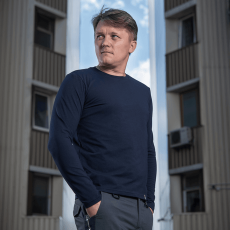 Mies M-Tac Long-sleeve T-shirt 93/7 päällä rakennuksen edessä, 93% puuvillaa ja 7% elastaania kestävyyttä ja muotopysyvyyttä varten.