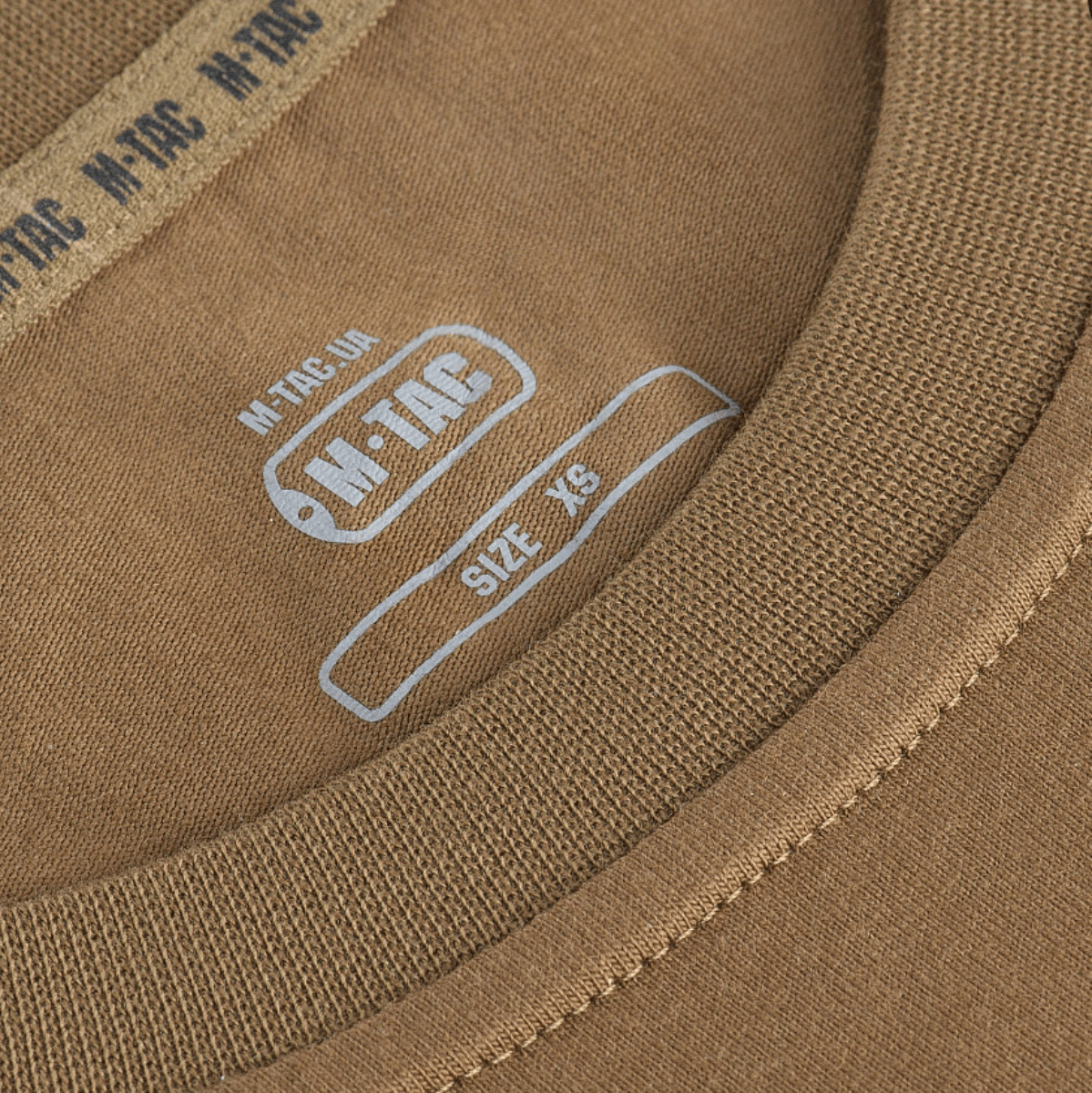 Lähikuva M-Tac Long-sleeve T-shirt 93/7 ruskean paidan kauluksesta, merkki näkyvissä.