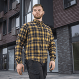 M-Tac Redneck -paita navy sininen/keltainen ruutukuosi, tyylikäs ja kestävä taktinen paita työhön ja vapaa-aikaan, nähty henkilöllä rakennusten edessä.