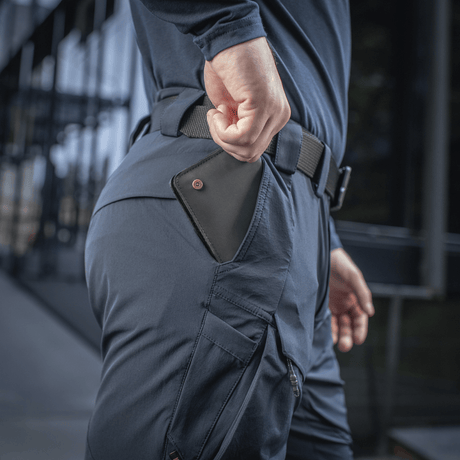 Henkilö pukeutuneena M-Tac Rubicon Flex -housuihin innovatiivisella cargo-taskulla harjoitteluun, työhön ja vapaa-aikaan. Toiminnalliset ja modernit housut.