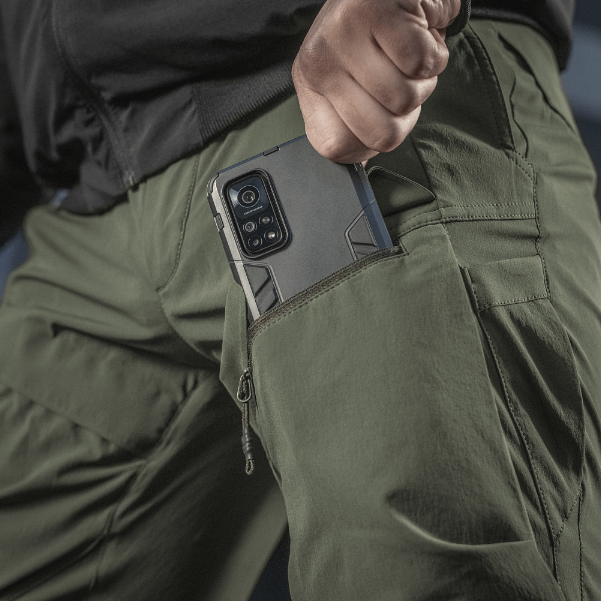 M-Tac Rubicon Flex vihreänä, innovatiivinen cargo-tasku ja puhelin, sopii treeniin ja ulkoaktiviteetteihin.