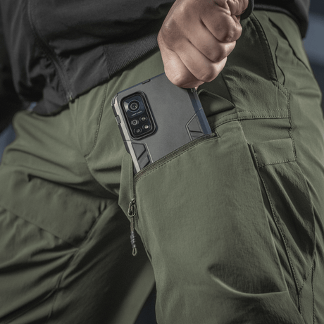M-Tac Rubicon Flex vihreänä, innovatiivinen cargo-tasku ja puhelin, sopii treeniin ja ulkoaktiviteetteihin.