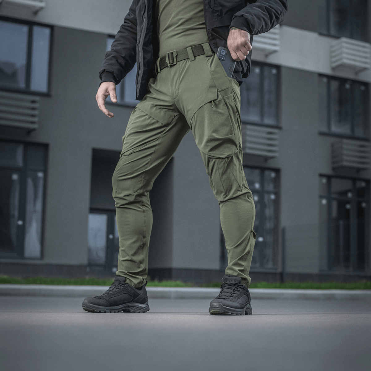 M-Tac Rubicon Flex innovatiivisella cargo-taskulla, sopivat treeniin ja työhön oliivinvärisenä, esitetty ulkona.