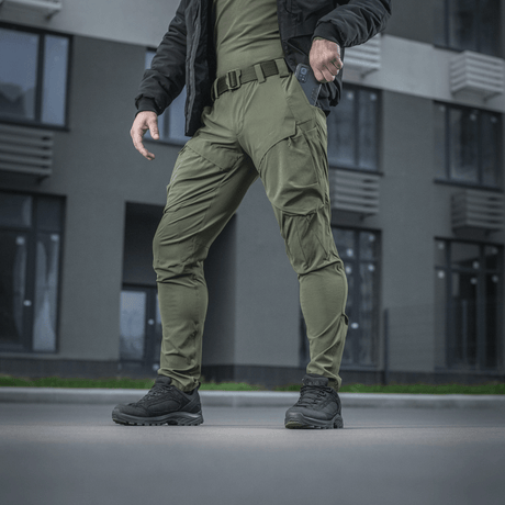 M-Tac Rubicon Flex innovatiivisella cargo-taskulla, sopivat treeniin ja työhön oliivinvärisenä, esitetty ulkona.