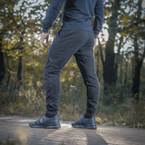 Mies pukeutuneena M-Tac Stealth Cotton -housuihin, urheiluhousut 100% puuvillaa, sopivat juoksuun ja arkeen.