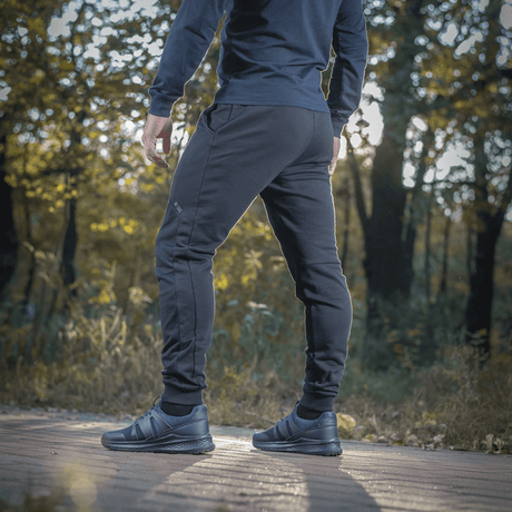 Mies pukeutuneena M-Tac Stealth Cotton -housuihin, urheiluhousut 100% puuvillaa, sopivat juoksuun ja arkeen.